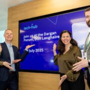Two men and two women gesturing at a screen.