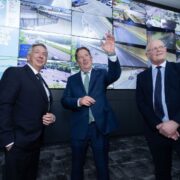 Three men in suits at a motorway control centre in Ireland.