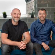 Two men sitting on a couch.