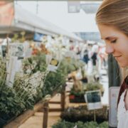 Young woman browsing among plants in a garden centre.