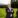 Man in suit standing in a field beside a tractor.