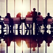 Large group of people around a boardroom table.