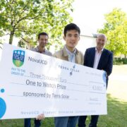 Three men with one holding a large cheque.