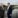 Two business men shake hands beside a river.