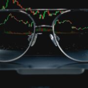 Pair of glasses in front of an FX markets screen.