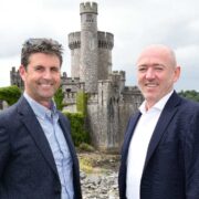 Two men standing in front of a castle turret in Cork.