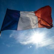 The flag of France under a blue sky.