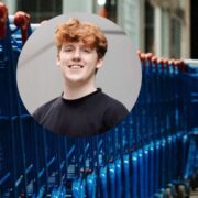 Young man with red hair inset on image of shopping trolleys.