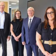 Two women in black and men in suits.