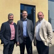 Three men outside a building.