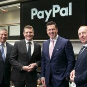 Four men beneath a PayPal sign.