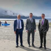 Three men in suits on a beach at Achill Island.