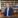 Man in navy suit sitting in a library.