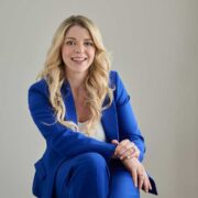 Fair-haired woman in blue suit.