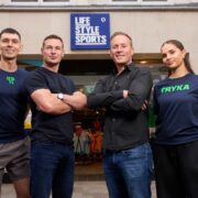 Three men and a woman outside a sports store.