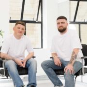 Two men in white t-shirts in salon chairs.