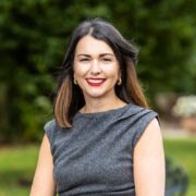 Dark-haired woman in grey dress.