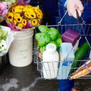 Man carrying a basket of grocery goods.