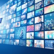 Woman standing in front of a wall of screens.