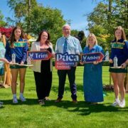 Group of adults and young adults standing in a field.