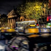 Nighttime scene in Dublin with Bank of Ireland College Green in background.