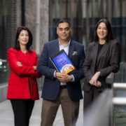Two women and a man holding a report.