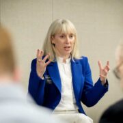 Woman in blue jacket speaking.