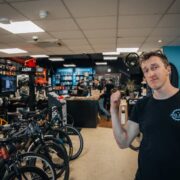 Man in black t-shirt in bicycle shop.