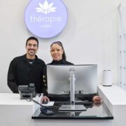 Man and woman at front desk of a Therapie aesthetics clinic.