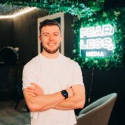 Man in white t-shirt with arms folded.