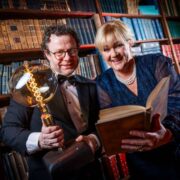 Man and woman with an award in a library.