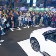 Crowd of curious consumers at an electric car show.