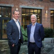 Two men standing in front of a building.