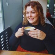 Smiling woman holding a cup of coffee.