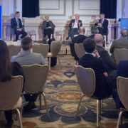 People at an event watching economists on stage.