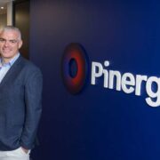Man in sports jacket beside a Pinergy logo.