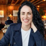 Dark-haired woman in navy jacket.
