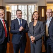 Three men and a woman in business atire.