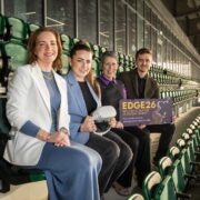 Women and a man in a stadium.