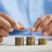 Worker in blue shirt counting coins.