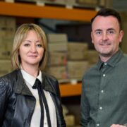 Man and woman standing in a warehouse.