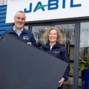 Man and woman holding a solar panel.