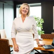 Woman in white dress in boardroom.