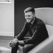 smiling man sitting on a chair.