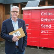 Man in navy jacket standing in front of new DPD parcel lockers.