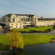 Aerial view of Knightsbrook Hotel Spa and Golf Resort in Trim, Co Meath, showing the four star hotel buildings, golf clubhouse, landscaped grounds and water feature surrounded by parkland.