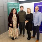 Four people stand side by side at an indoor event space, posing for a photo in front of Enterprise Ireland and Learnovate branded banners associated with research, innovation and learning technology.