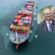 Cargo container ship loaded with multicoloured shipping containers sailing over a stylised world map, with a circular inset showing a professional portrait of a spokesperson in business attire, illustrating international trade and global markets.