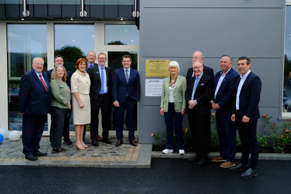 Group of officials and stakeholders gathered outside the Future Cast innovation centre in Manorhamilton, Co Leitrim, standing beside a commemorative plaque at the building entrance.