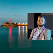 Portrait of a speaker seated on stage overlaid on a calm Dublin Bay scene with a lighthouse at dusk and reflections on the water.